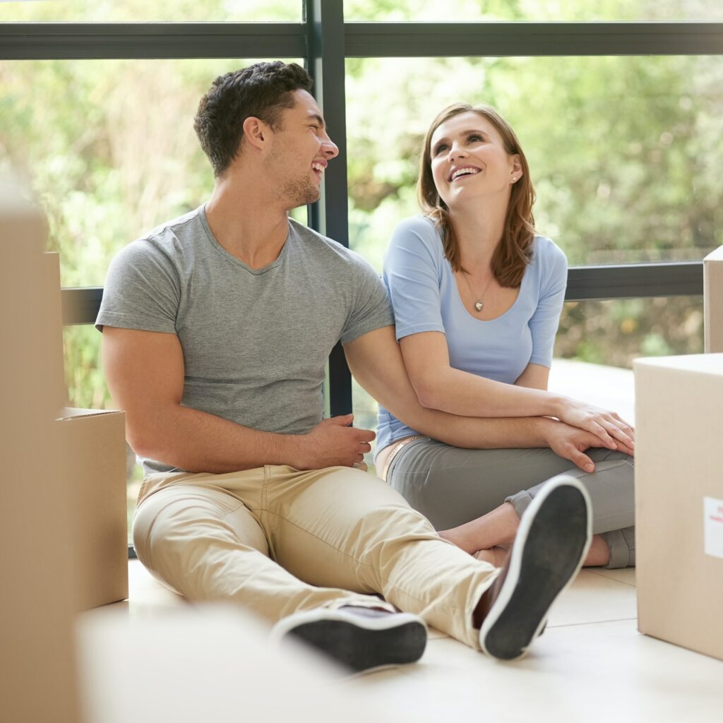 Shot of a happy young couple relaxing in their new home while moving in